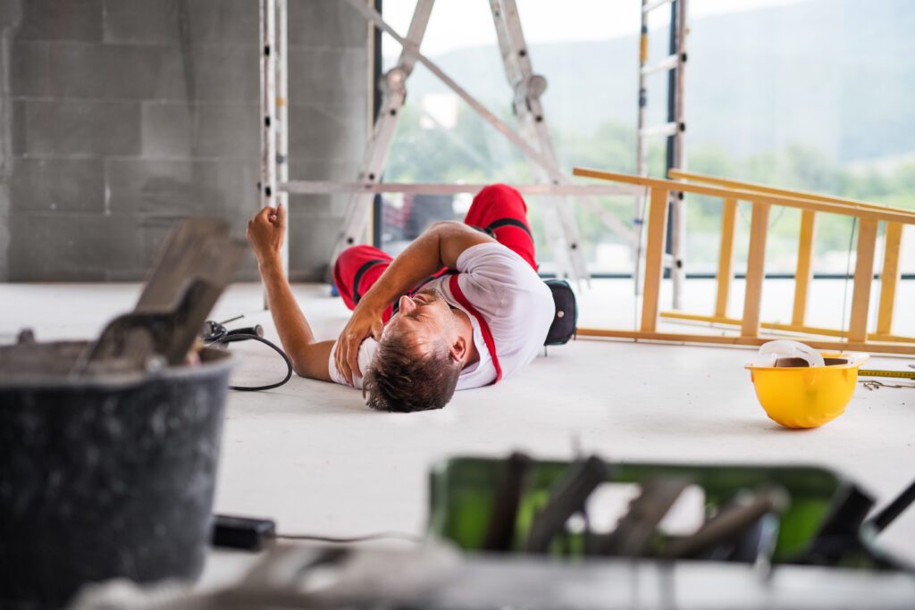 man lying on his back in pain on a construction site