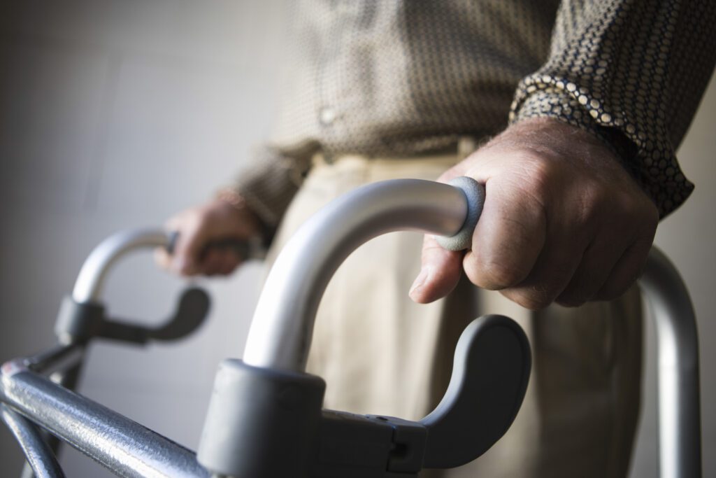 elderly man holding onto his walker