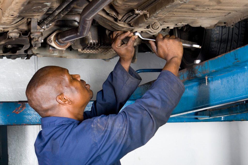 rhode island auto mechanic works on a car overhead.