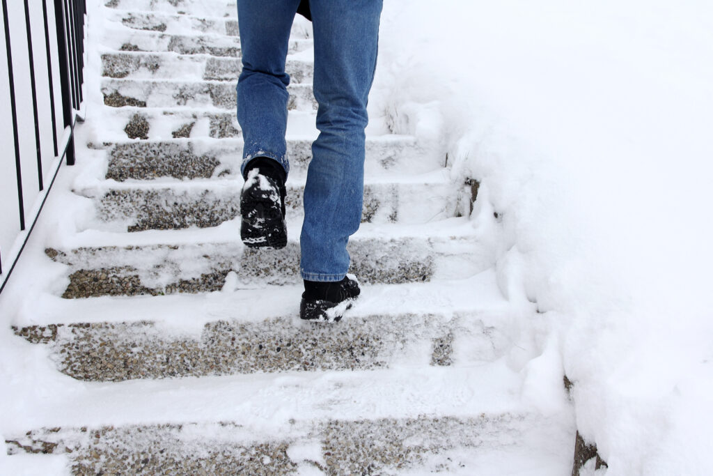 person walking up snowy staircase