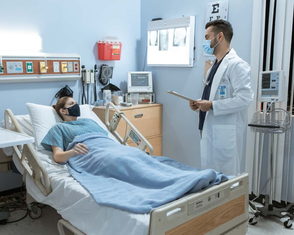patient in bed speaking with doctor 