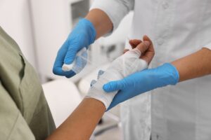 A patient at a doctor’s office getting their hand bandaged, wondering, “How much compensation can you get for a burn injury?”