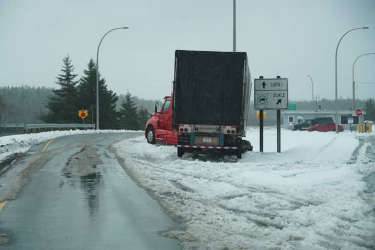 18-wheeler on the side of the road in the snow after a collision, leaving the involved parties to wonder about the average settlement for an 18-wheeler accident.