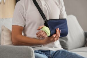 A man with his arm in a sling, wondering, “Can a lawsuit be reopened after settlement in Rhode Island?