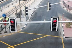 Red traffic signals hanging over an intersection with yellow lane markings